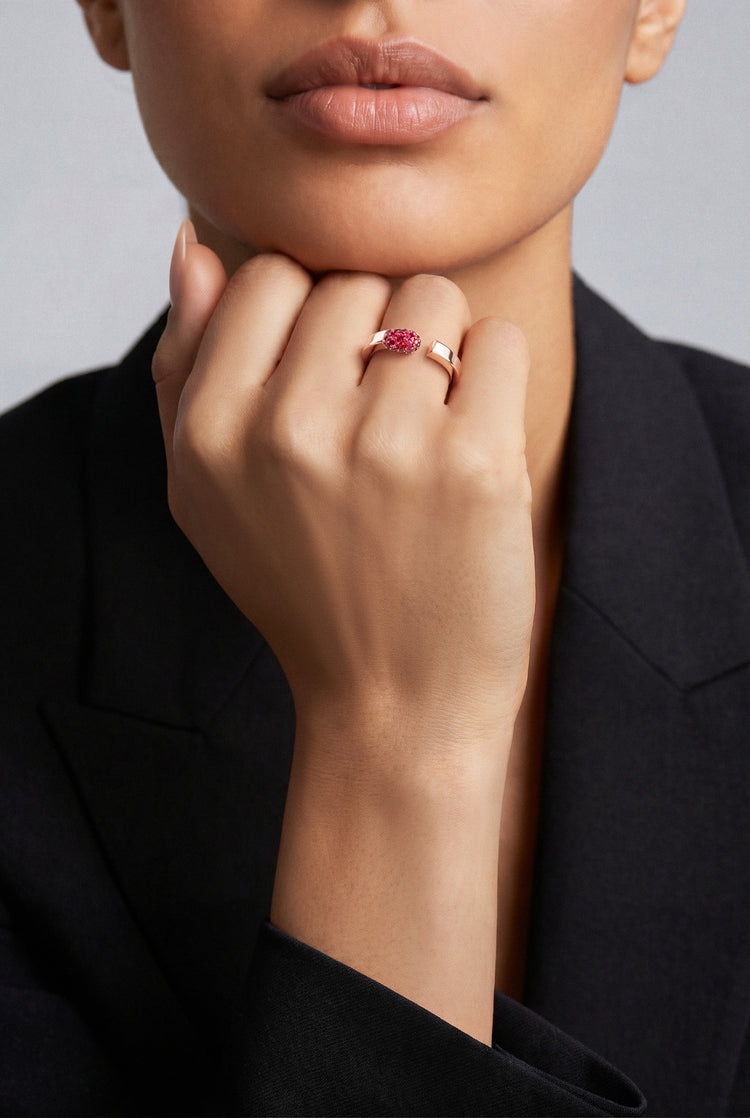 Model wearing a Ring in 18k Rose Gold with Rubies and a black blazer