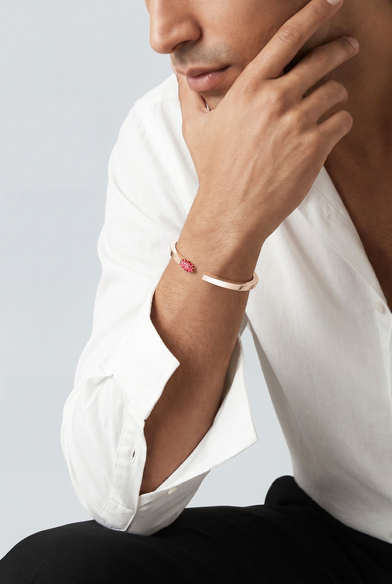 Model wearing a Bracelet in 18k rose gold with rubies and white shirt