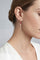 Model wearing Earrings in 18k rose gold with rubies and white shirt
