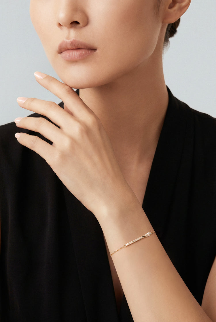Model wearing a black V neck top and a Bracelet in 18k Rose gold with white and champagne diamonds