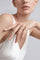 Model wearing a white look and a Ring in 18k Rose Gold with White and Champagne Diamonds.