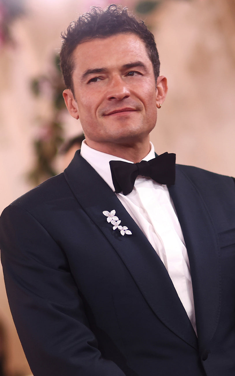 Orlando Bloom wearing our brooch in 18k White Gold with White Diamonds on a black jacket.